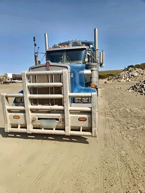 Front view of a Sand Man Trucking Kenworth with a bull bar